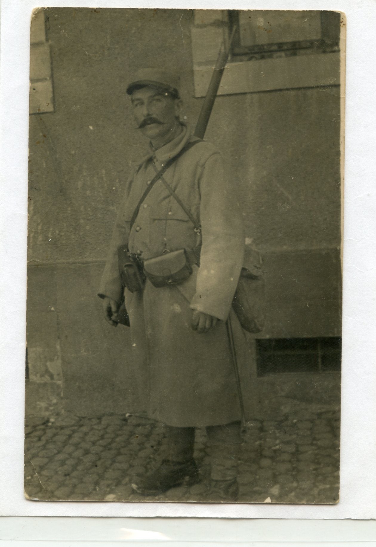 carte photo d'un poilu redescendant des lignes équipé capote Poiret vers 1915 texte au dos
