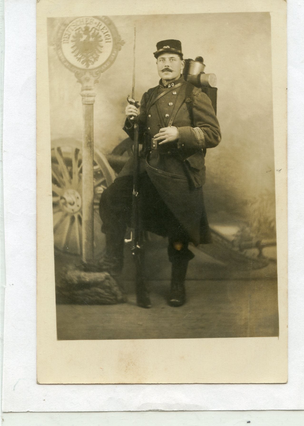 carte photo d'un poilu de 20°RIT équipé devant panneau allemand 1914