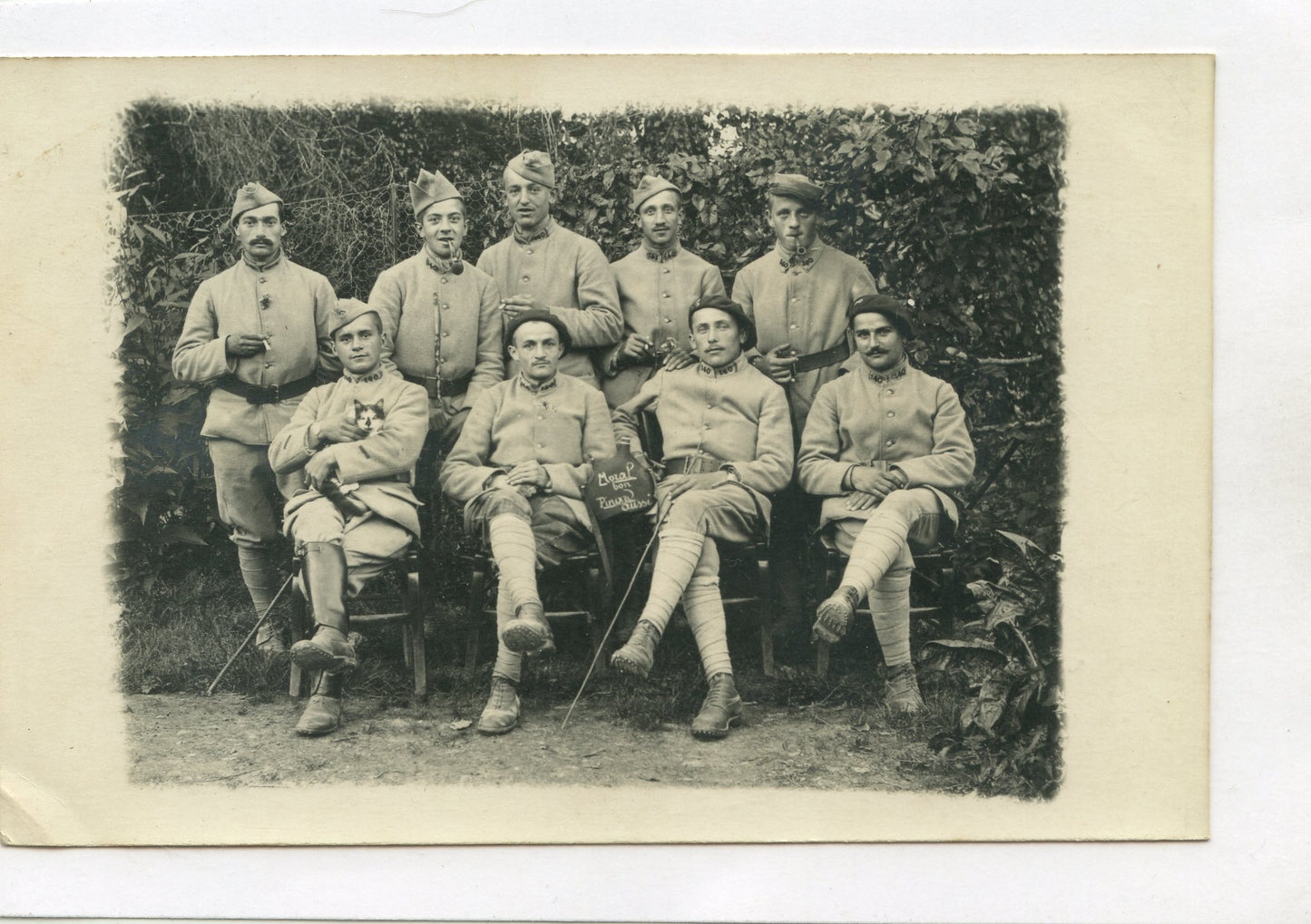 carte photo d'un groupe de poilus du 140° rgt d'infanterie "moral bon, pinard aussi" sur la pancarte 1917